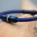Zijkant van blauwe sailrope heren gedenkarmband met crematie-as in zwarte rvs bedel.