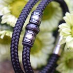 Heren gedenkarmband van zwarte sailrope met crematie-as in rvs bedel en zilverkleurige schuifsluiting.