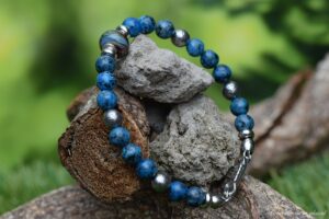 een heren armband van blauw petrol graniet natuursteen met crematie-as glas bedel
