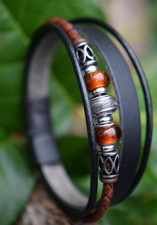 heren geenkarmband van zwart leder met haarverwerking en glazen bedels verwerkt op de band