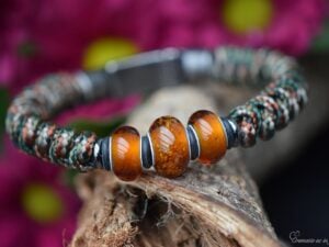 Heren gedenkarmband met woodland camo knoopwerk en drie transparant amber glasbedels waarvan de middelste crematie-as bevat.